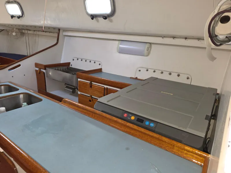 Slide: The Image of Interior of 1986 Santa Cruz 50 yacht kitchen with sink, stove, and wooden cabinetry. - 21