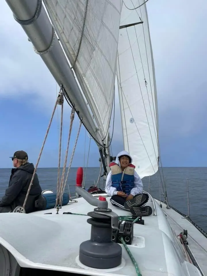 Slide: The Image of Two people sailing on a 1986 Santa Cruz 50 yacht under clear skies. - 6