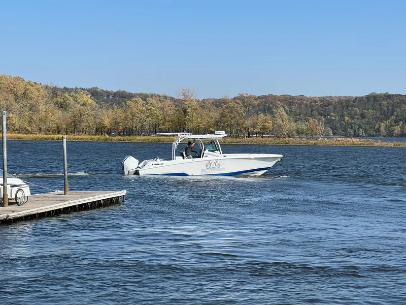 Slide: The Image of 2023 Wellcraft 302 Fisherman boat docked by a wooden pier on a sunny day. - 11