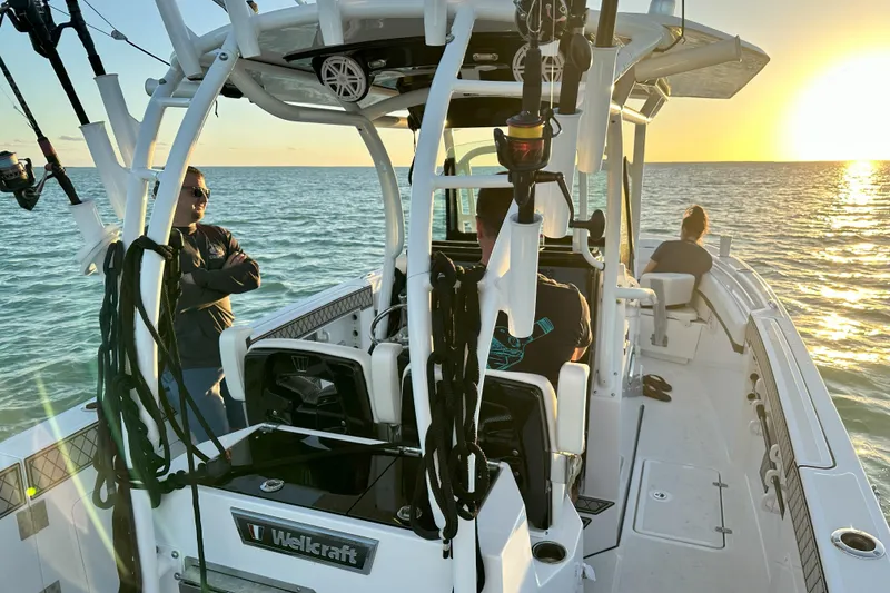 Slide: The Image of 2023 Wellcraft 302 Fisherman boat at sunset with people enjoying the ocean view. - 27
