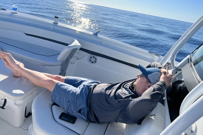 Slide: The Image of Man relaxing on 2023 Wellcraft 302 Fisherman boat under sunny skies. - 31