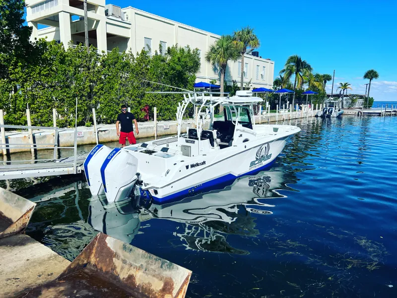 Slide: The Image of 2023 Wellcraft 302 Fisherman boat illuminated with blue LED lights at night. - 5