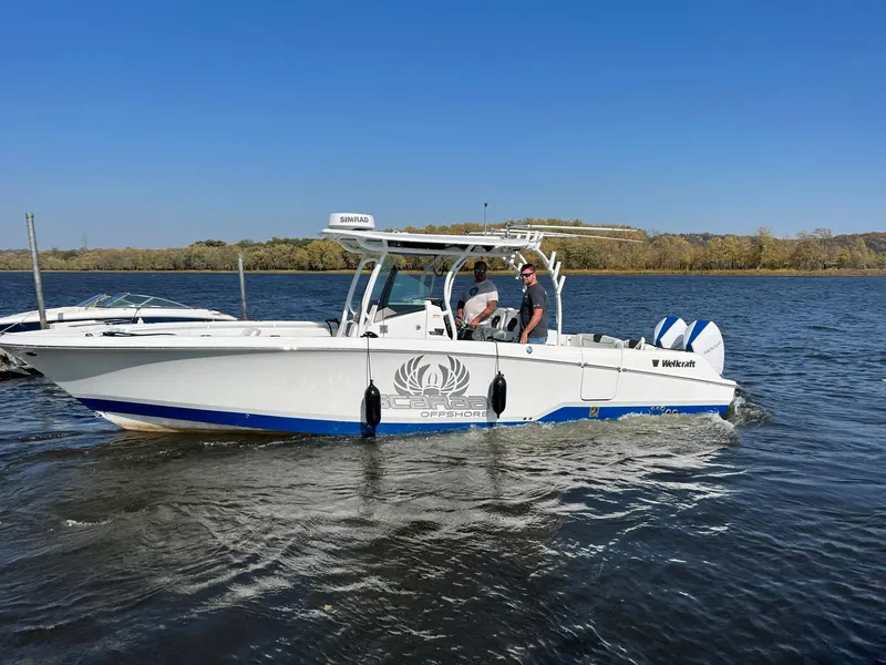 Slide: The Image of 2023 Wellcraft 302 Fisherman boat on trailer, parked outdoors on a rainy day. - 8