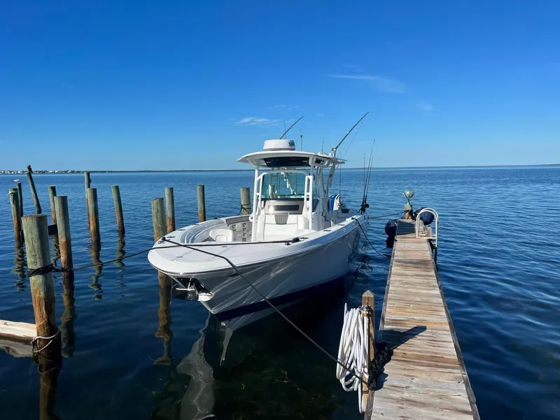 Slide: The Image of 2023 Wellcraft 302 Fisherman boat on water with people onboard, clear blue sky. - 9