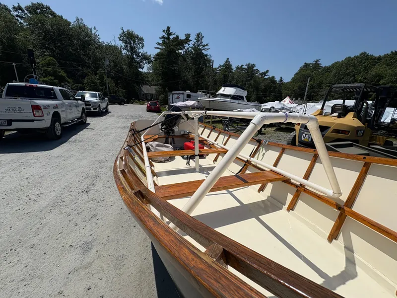 Slide: The Image of 2017 Custom Houghs Neck Skiff 176 in a boatyard, surrounded by vehicles and trees. - 5