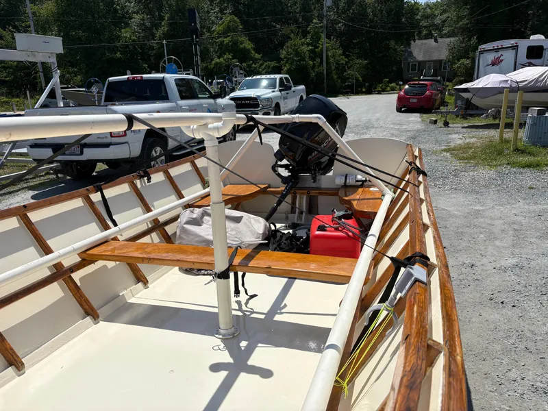 Slide: The Image of Custom Houghs Neck Skiff 176 boat, 2017 model, parked near vehicles on a sunny day. - 9