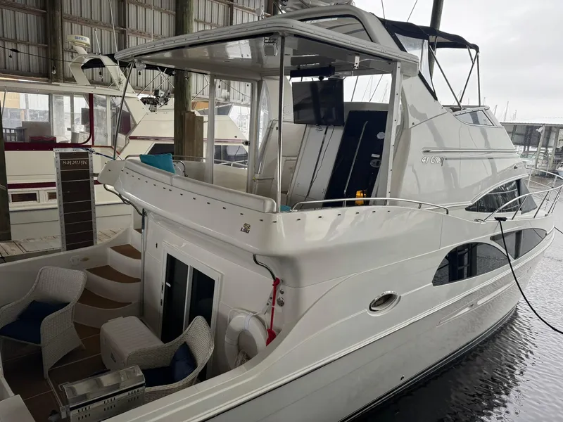 Slide: The Image of 2006 Carver 41 Cockpit Motor Yacht docked in a marina, featuring spacious deck and seating. - 34