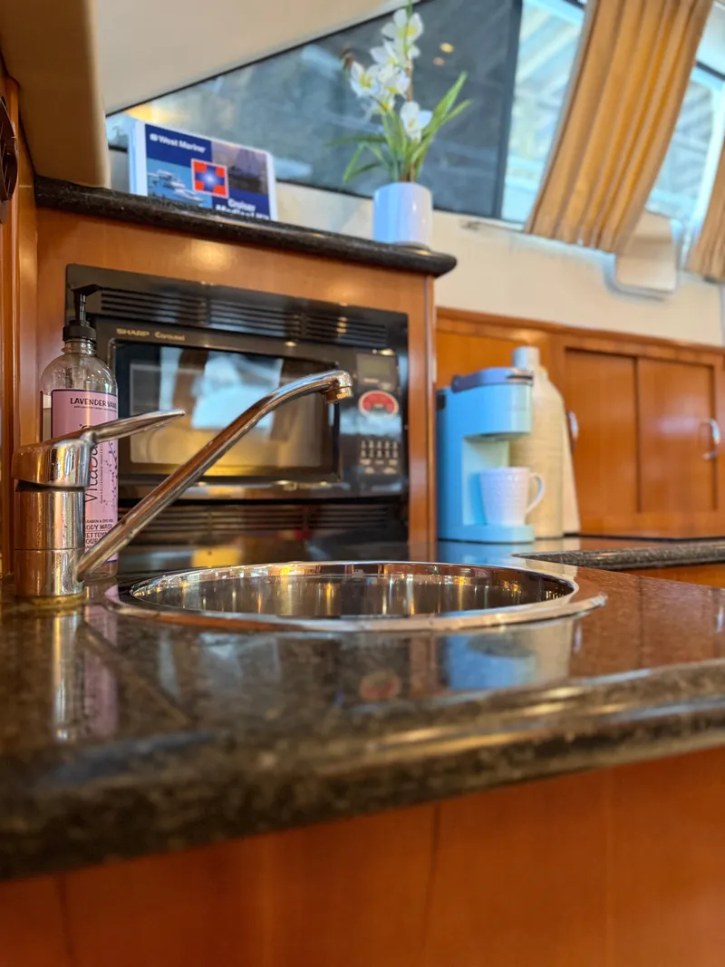 Slide: The Image of 2006 Carver 41 Cockpit Motor Yacht kitchen with sink, microwave, and coffee maker. - 16