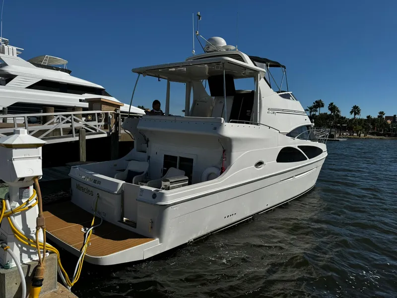 Slide: The Image of 2006 Carver 41 Cockpit Motor Yacht docked at marina under clear blue sky. - 2