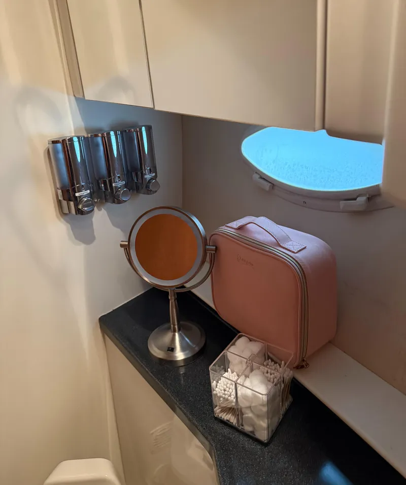 Slide: The Image of Bathroom vanity area in a 2006 Carver 41 Cockpit Motor Yacht with mirror and toiletries. - 28