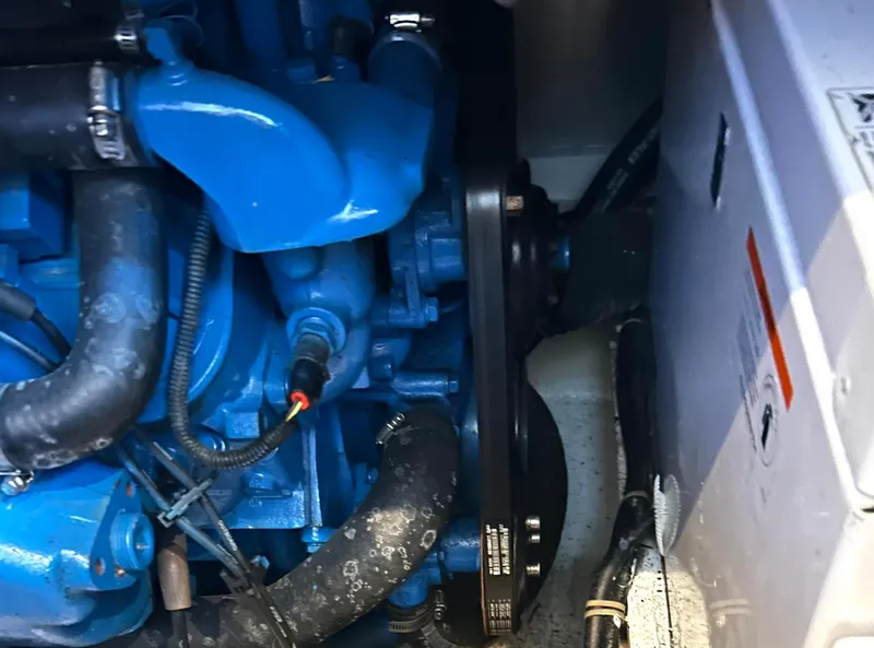 Slide: The Image of Engine components of a 2006 Carver 41 Cockpit Motor Yacht, featuring blue hoses and belts. - 38