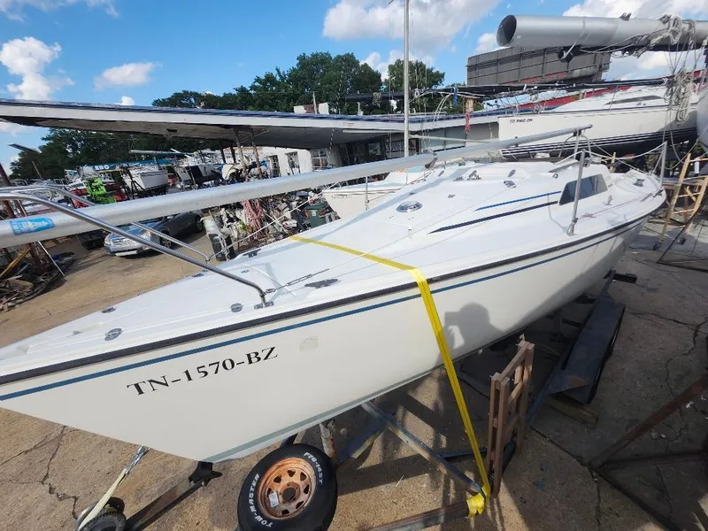 Slide: The Image of 1988 Hunter 23 sailboat on trailer, parked outdoors under a blue sky. - 13