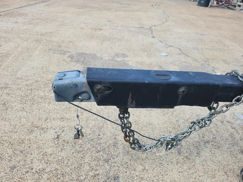 Slide: The Image of Trailer hitch with safety chain and keys on concrete ground. Hunter 23, 1988 model. - 19