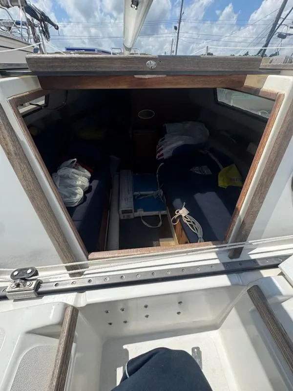Slide: The Image of Interior view of a 1988 Hunter 23 sailboat cabin with blue cushions. - 2