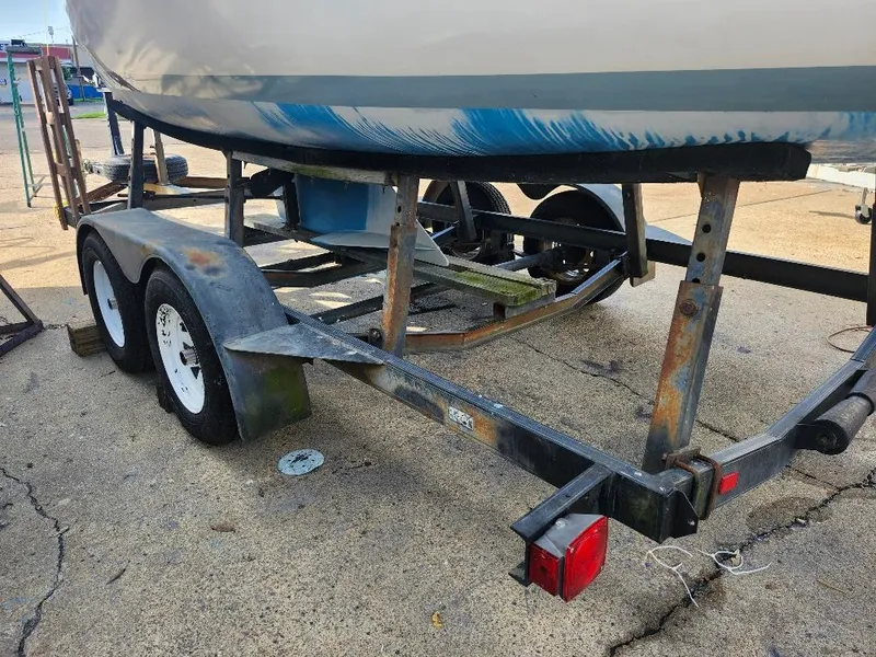 Slide: The Image of 1988 Hunter 23 sailboat on a rusty trailer, parked on concrete. - 21