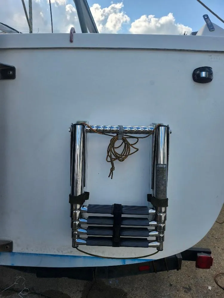 Slide: The Image of Rear view of 1988 Hunter 23 boat with folded ladder and rope. - 23