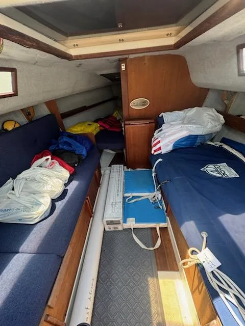 Slide: The Image of Interior of 1988 Hunter 23 sailboat with blue seating and storage items. - 3