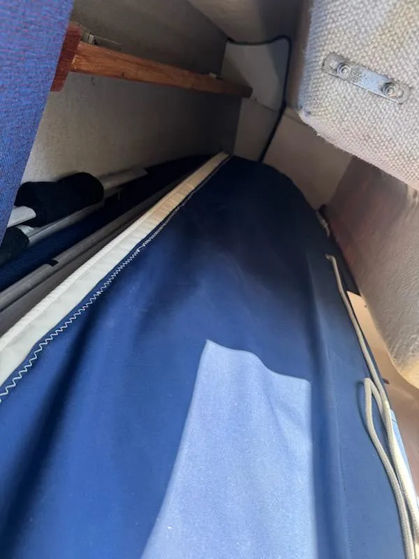 Slide: The Image of Interior view of a 1988 Hunter 23 sailboat with blue fabric and wooden accents. - 4