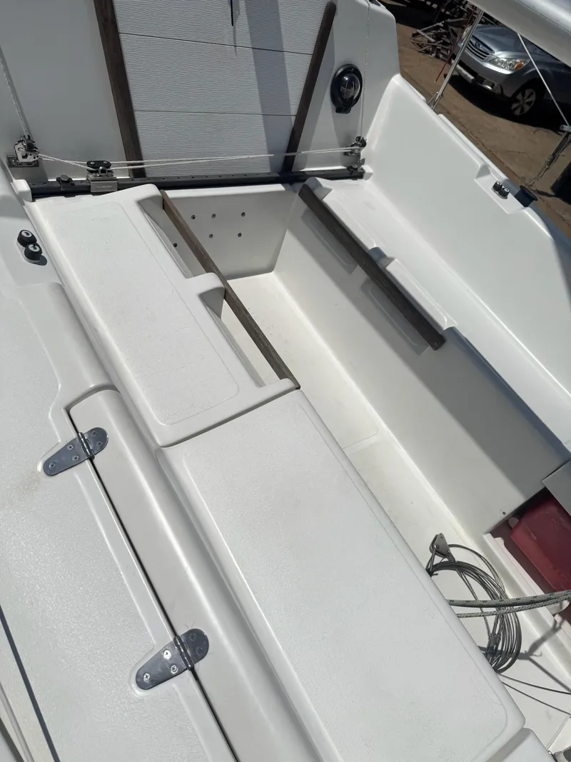 Slide: The Image of 1988 Hunter 23 sailboat cockpit with white seating and storage compartments. - 7