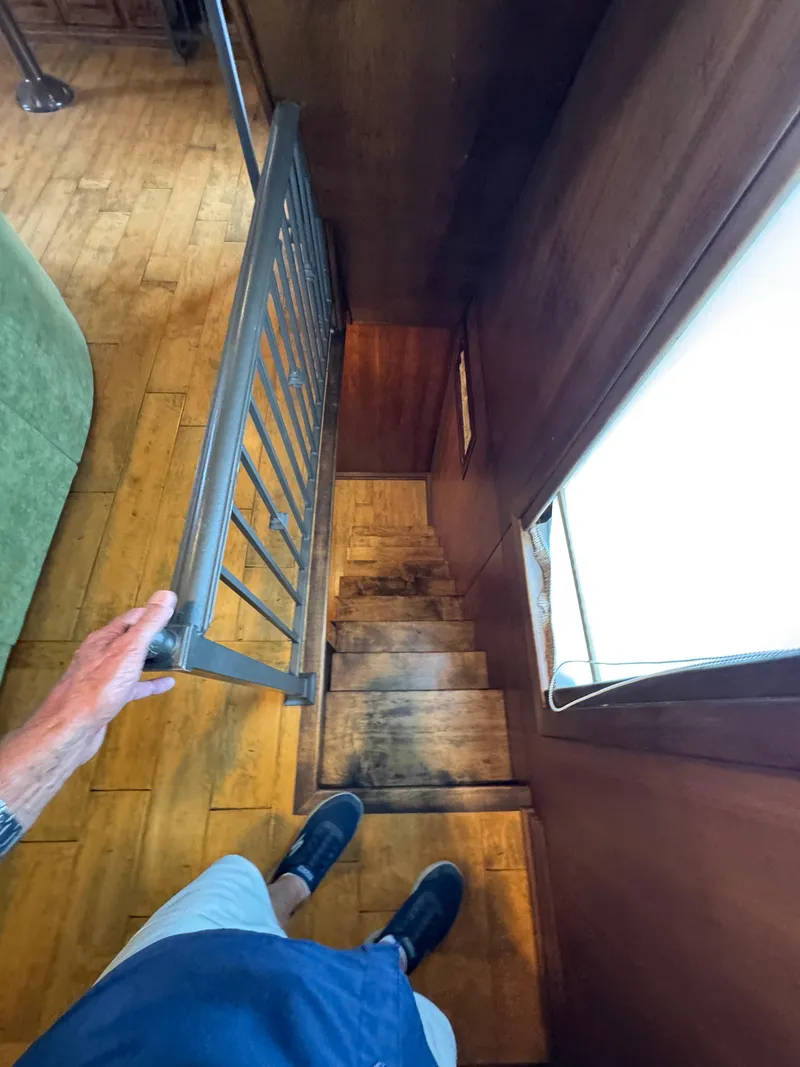 Slide: The Image of Interior view of a 2003 custom houseboat staircase with wooden steps and metal railing. - 10