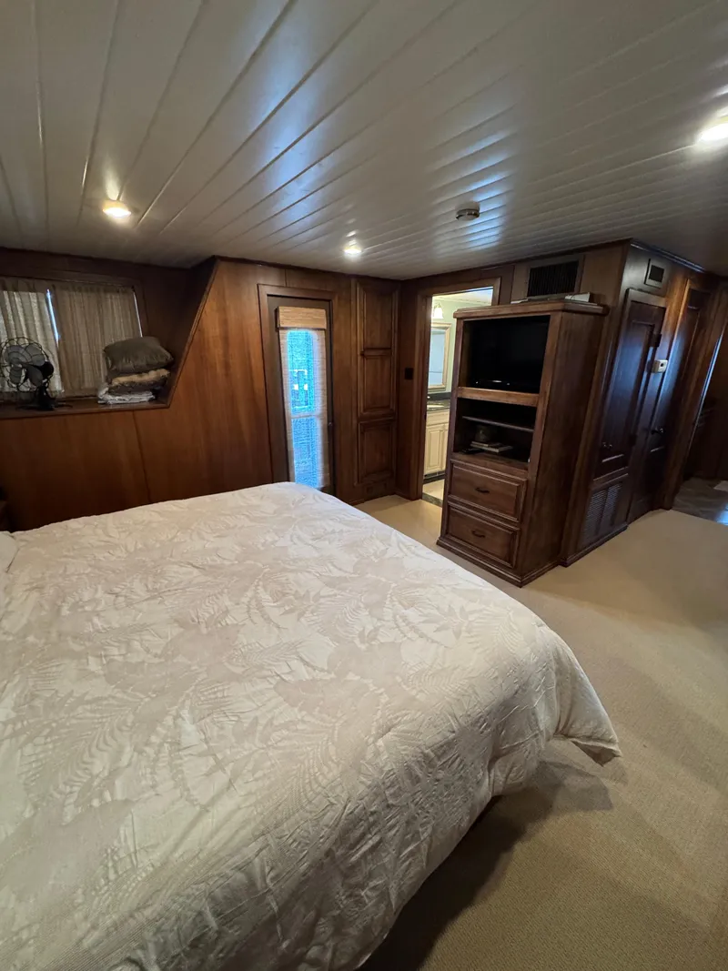 Slide: The Image of Cozy bedroom in a 2003 custom houseboat with wood paneling and a comfortable bed. - 16