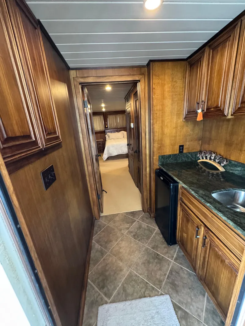 Slide: The Image of Luxurious 2003 custom houseboat interior with wood cabinetry, mini fridge, and cozy bedroom view. - 17