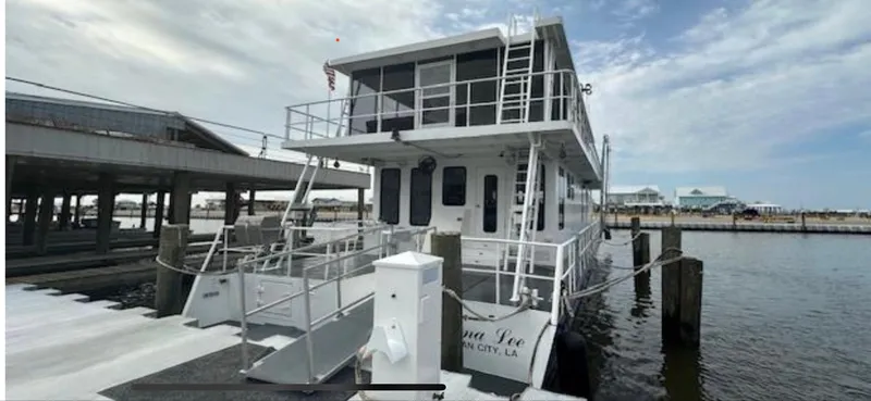 Slide: The Image of Custom 2003 houseboat docked at marina, featuring upper deck and modern design. - 2