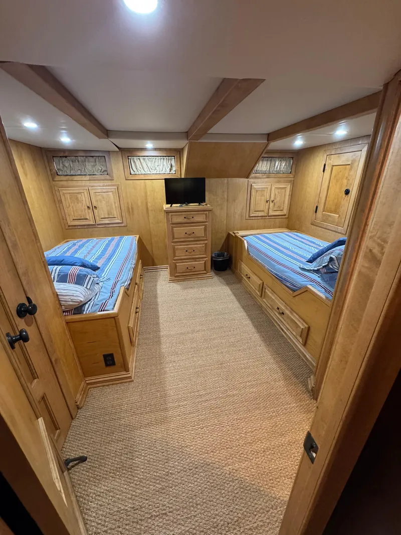 Slide: The Image of Cozy houseboat bedroom with twin beds, wooden cabinetry, and a small TV, 2003 model. - 20