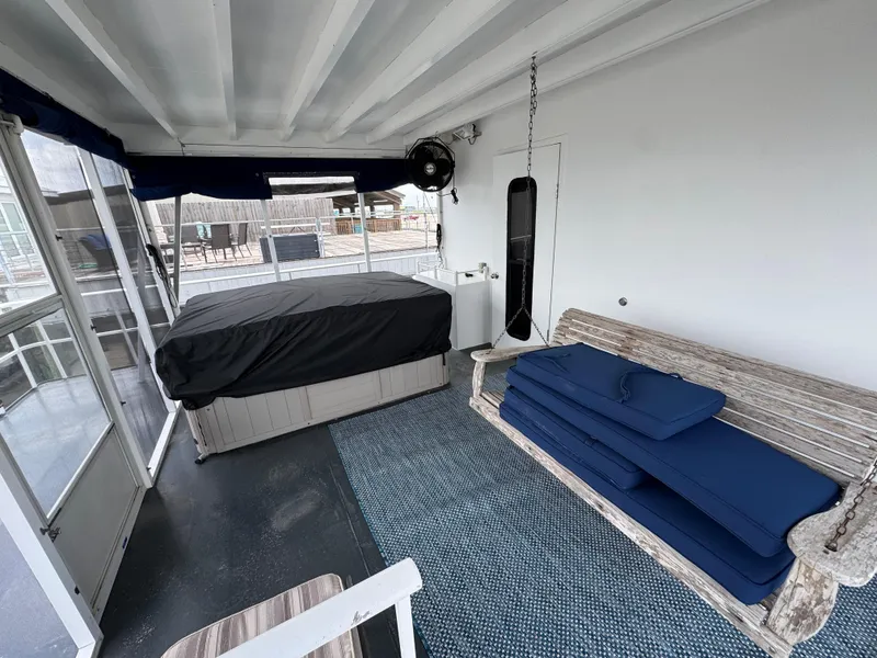 Slide: The Image of Houseboat interior with swing bench, cushions, and covered hot tub, 2003 custom model. - 24