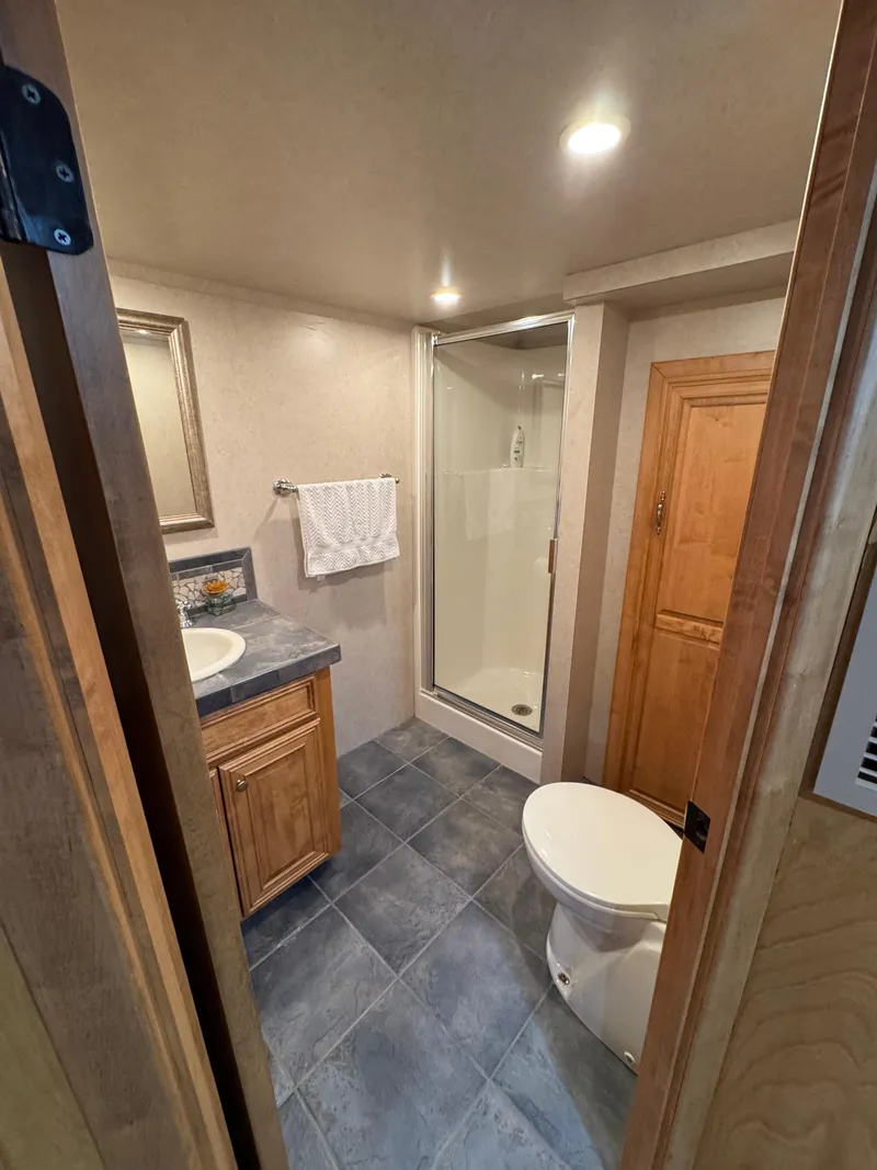 Slide: The Image of Compact houseboat bathroom with shower, toilet, and sink; modern design, wooden cabinetry, tiled floor. - 25