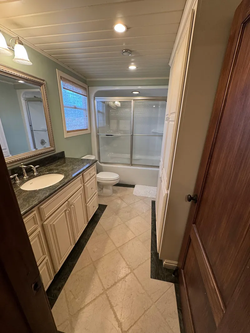 Slide: The Image of Luxurious houseboat bathroom with granite countertop, glass shower, and elegant lighting. - 26