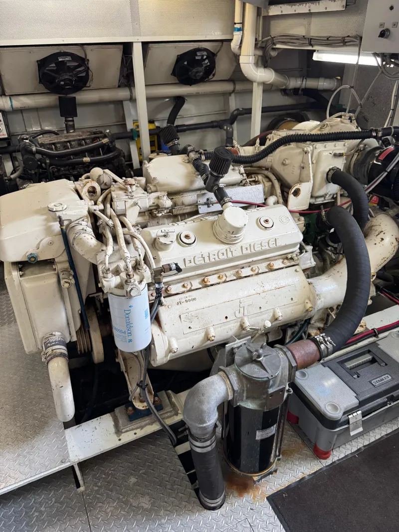 Slide: The Image of Engine room of a 2003 custom houseboat featuring a large diesel engine. - 31