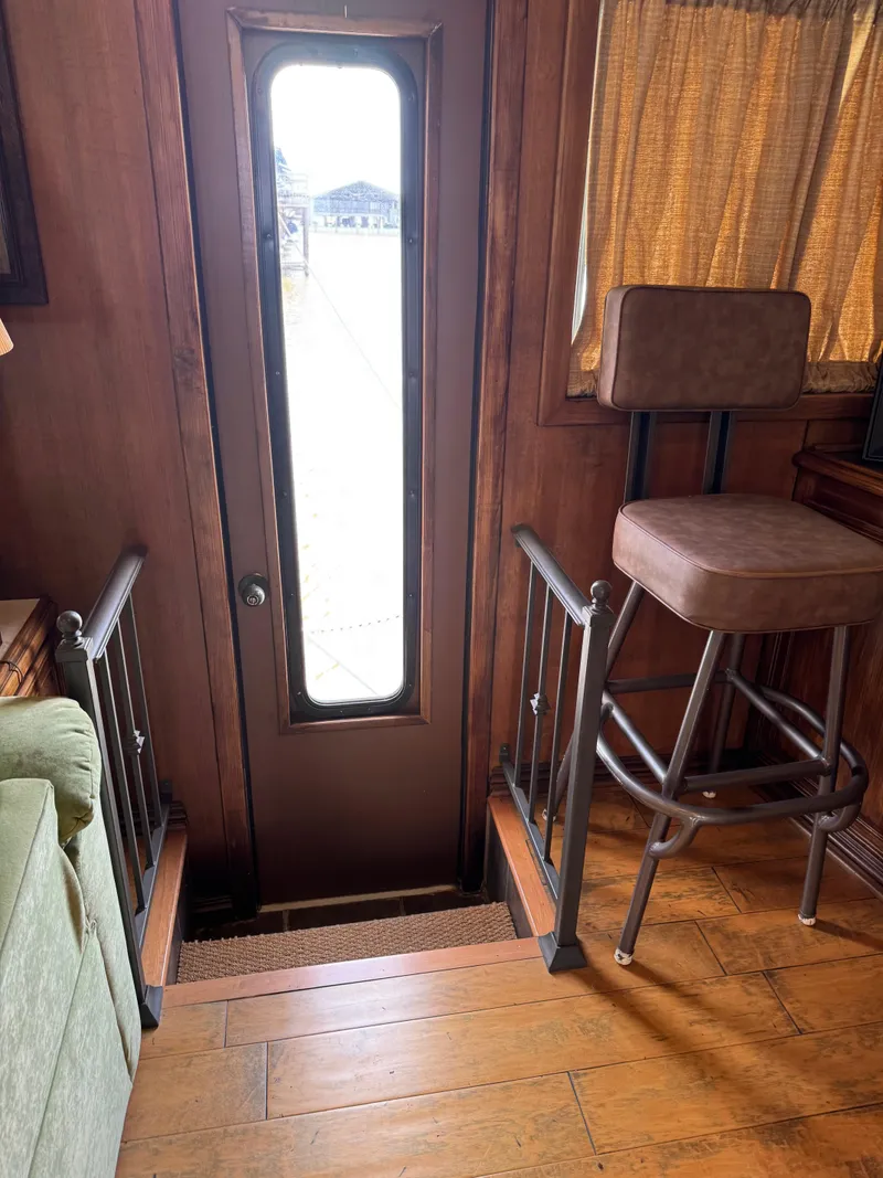 Slide: The Image of Interior of a 2003 custom houseboat with wooden flooring and a tall chair. - 36