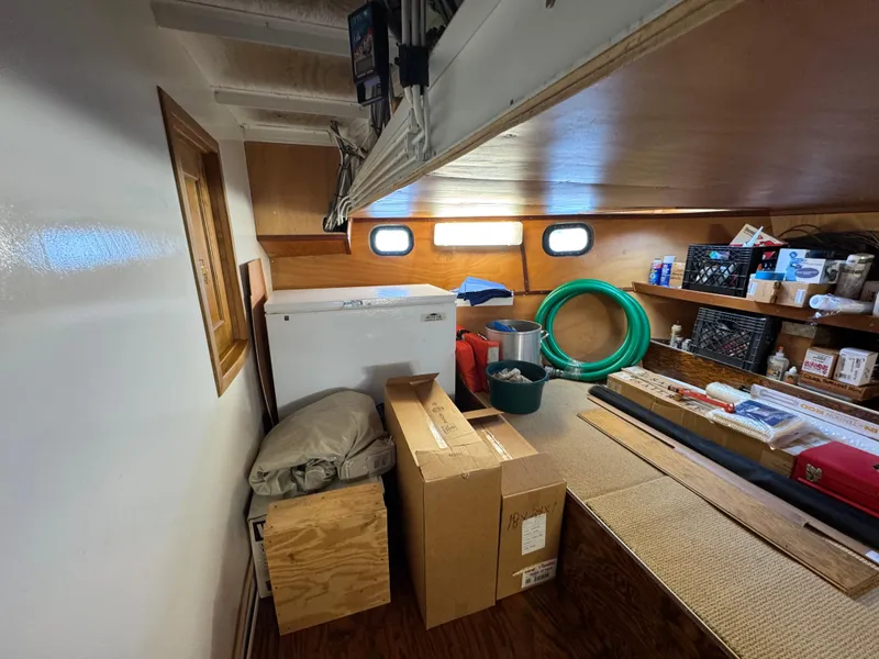 Slide: The Image of Storage area inside a 2003 custom houseboat with boxes, supplies, and equipment. - 39