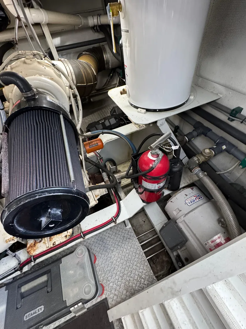 Slide: The Image of Engine room of a 2003 custom houseboat with fire extinguisher and mechanical components. - 42
