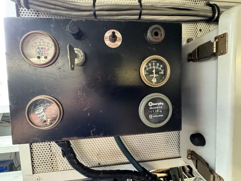 Slide: The Image of Control panel with gauges on a 2003 custom houseboat, displaying pressure, temperature, and hours. - 47