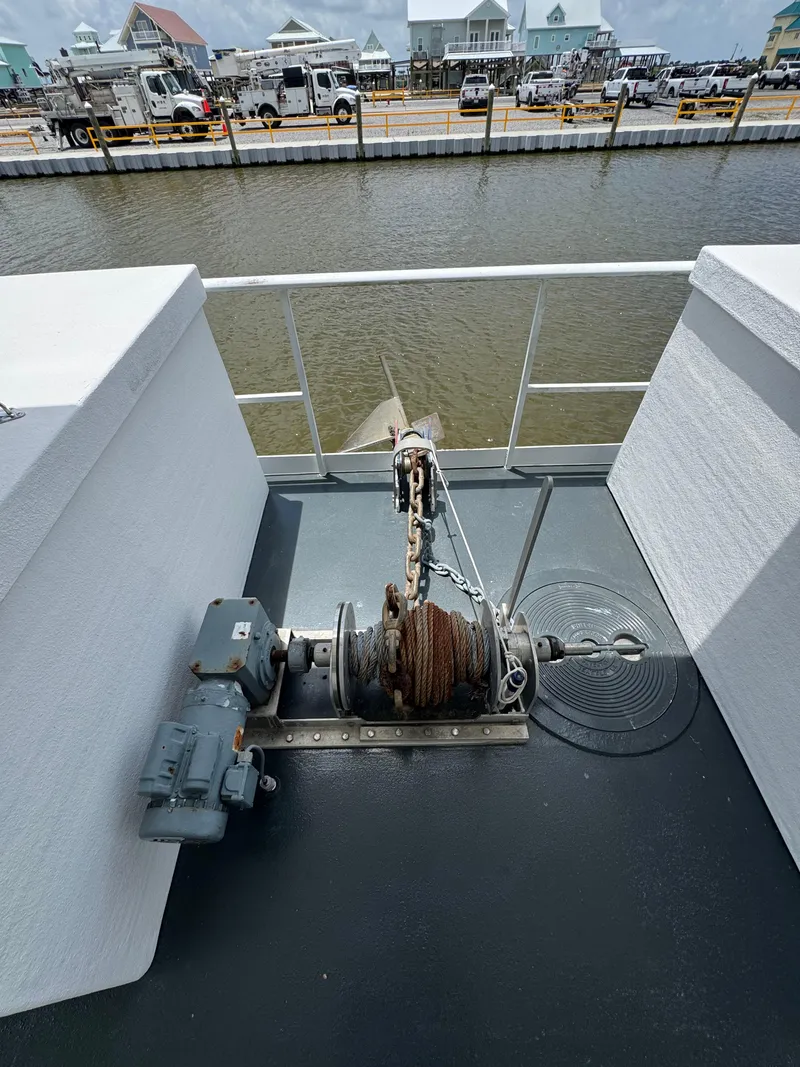 Slide: The Image of Houseboat deck with anchor winch, Custom model, 2003, docked near waterfront buildings. - 48