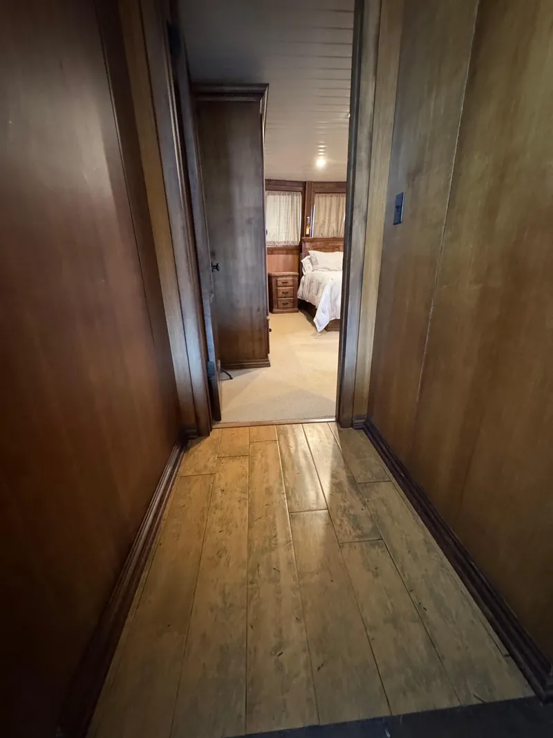 Slide: The Image of Narrow wooden hallway leading to a cozy bedroom on a 2003 custom houseboat. - 7