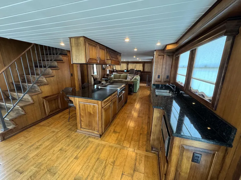 Slide: The Image of Luxurious 2003 custom houseboat interior with wooden cabinetry, granite countertops, and cozy living area. - 8