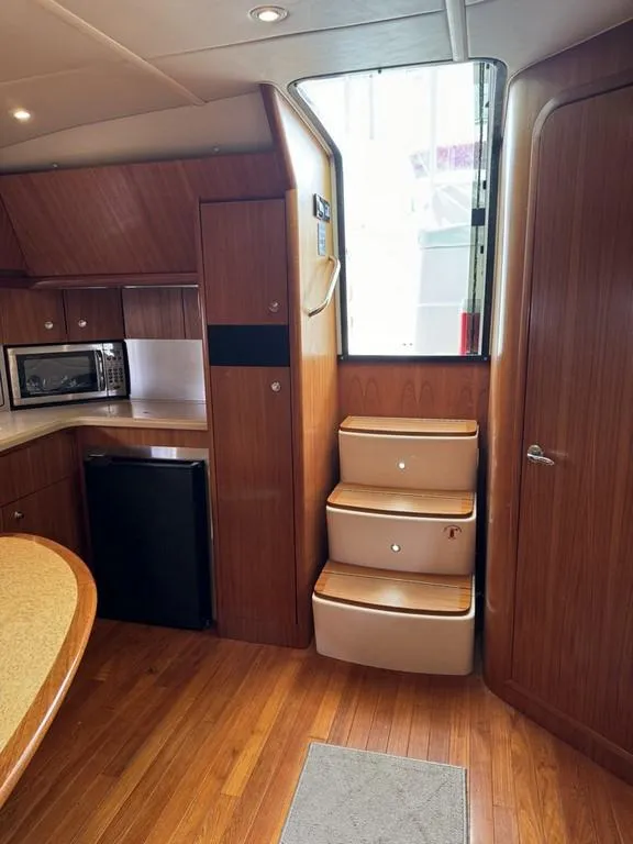 Slide: The Image of Interior of 2004 Tiara Yachts 3600 Sovran with wooden cabinetry and compact kitchen. - 12
