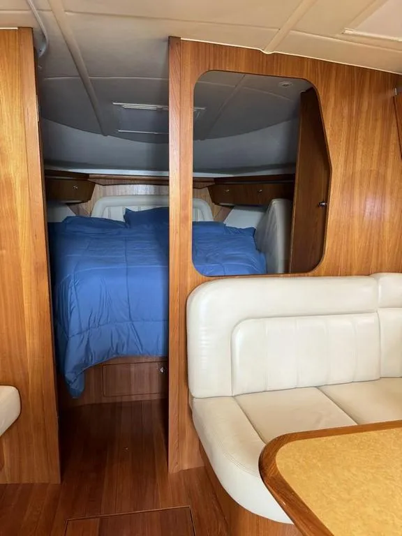 Slide: The Image of Interior of 2004 Tiara Yachts 3600 Sovran with wood finish and blue bedding. - 15