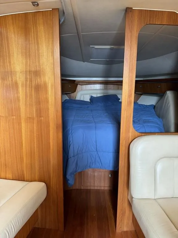 Slide: The Image of Interior cabin of 2004 Tiara Yachts 3600 Sovran with blue bedding and wooden finish. - 16