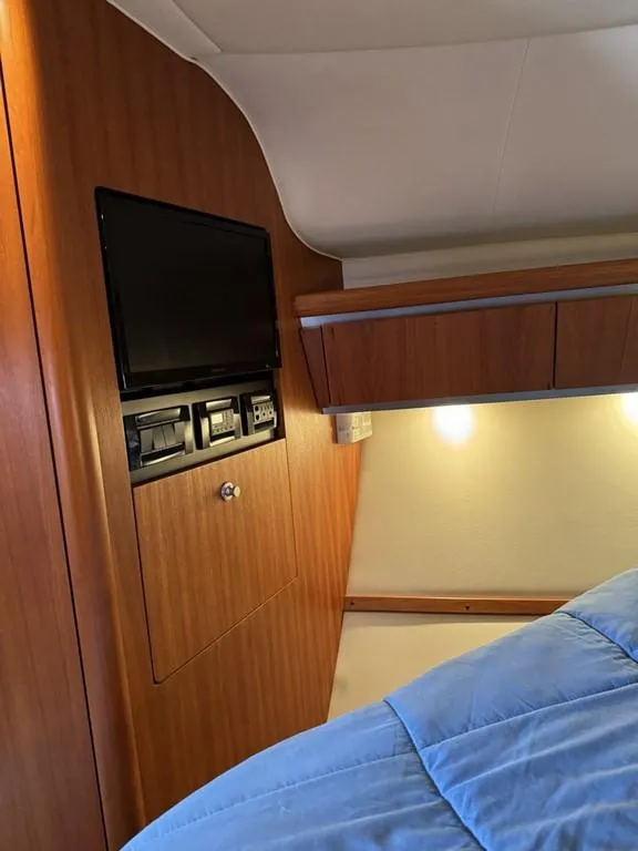 Slide: The Image of 2004 Tiara Yachts 3600 Sovran cabin interior with wood paneling and built-in TV. - 20