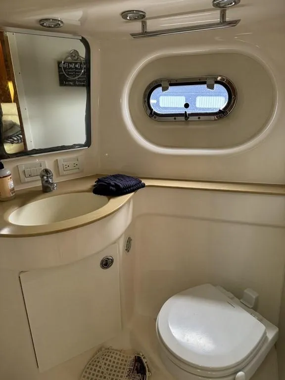 Slide: The Image of 2004 Tiara Yachts 3600 Sovran bathroom with sink, toilet, and porthole window. - 32