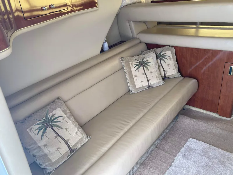 Slide: The Image of Interior of 2004 Sea Ray 400 Bridge Deck with beige sofa and palm tree pillows. - 16