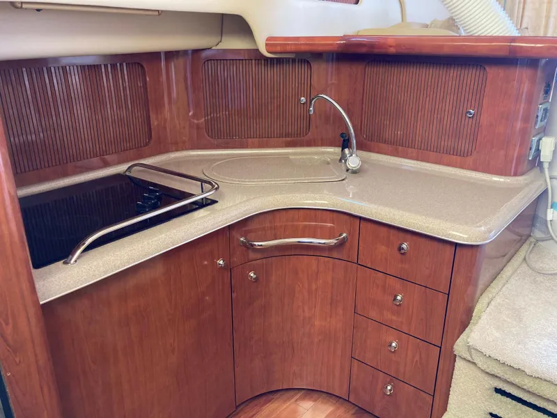Slide: The Image of 2004 Sea Ray 400 Bridge Deck kitchen with wood cabinetry and modern appliances. - 22