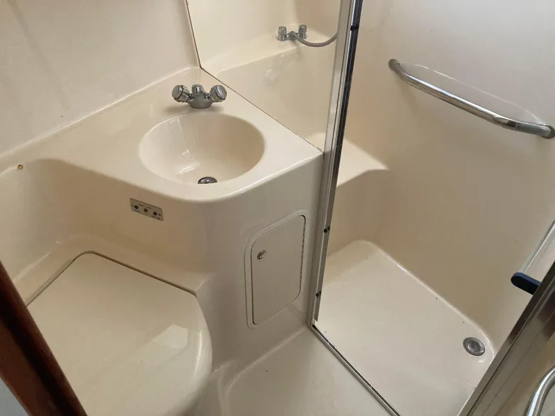 Slide: The Image of 2004 Sea Ray 400 Bridge Deck bathroom with sink, shower, and toilet. - 28