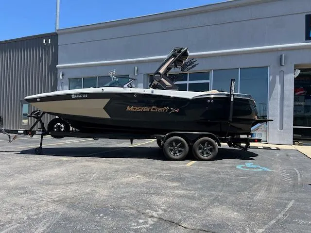 Slide: The Image of 2022 MasterCraft XStar S boat on trailer outside dealership. - 2