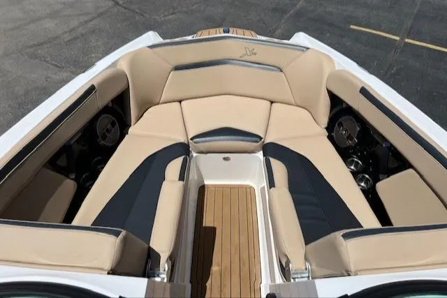 Slide: The Image of 2022 MasterCraft XStar S boat interior with beige and black seating, wooden flooring. - 20