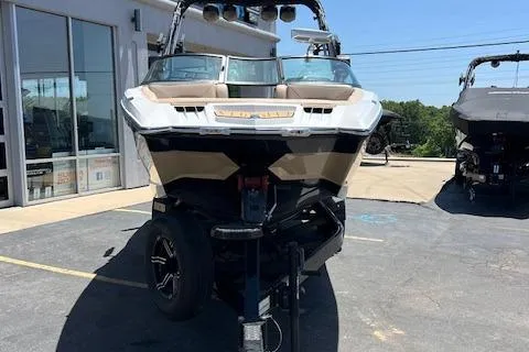 Slide: The Image of 2022 MasterCraft XStar S boat on trailer, parked outdoors near a building. - 22
